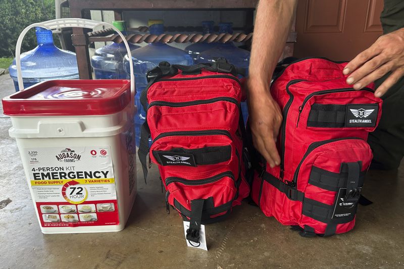 Chris Cole shows an emergency kit and pre-packed backpacks carrying essentials at his home while speaking with the Associated Press on Thursday, July 18, 2024, in Kula, Hawaii. (AP Photo/Jennifer Sinco Kelleher)