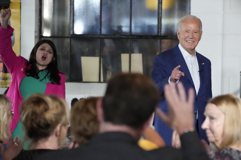 President Joe Biden, right, speaks as Rep. Haley Stevens, D-Mich., left, cheers during a visit to Garage Grill & Fuel Bar during a campaign stop in Northville, Mich., Friday July 12, 2024. (AP Photo/Jacquelyn Martin)