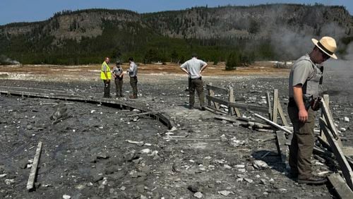 In this photo released by the National Park Service, park staff assess the damage to Biscuit Basin boardwalks after a hydrothermal explosion at Biscuit Basin in Yellowstone National Park, Wyo., Tuesday, July 23, 2024. (National Park Service via AP)