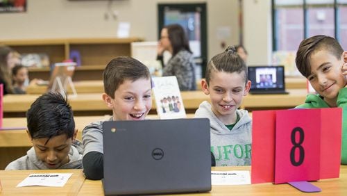 Buford Senior Academy students Ryan Robertson, left, Hayden Shepheard and Joshua Young, right, react as they watch a music video featuring music artist Lil Nas X during a Black History Month music themed event at their school’s library on Monday, Feb. 10, 2020. ALYSSA POINTER/ALYSSA.POINTER@AJC.COM