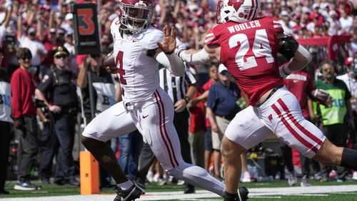 Alabama's Jalen Milroe (4) runs past Wisconsin's Hunter Wohler (24) for a touchdown during the second half of an NCAA college football game Saturday, Sept. 14, 2024, in Madison, Wis. (AP Photo/Morry Gash)