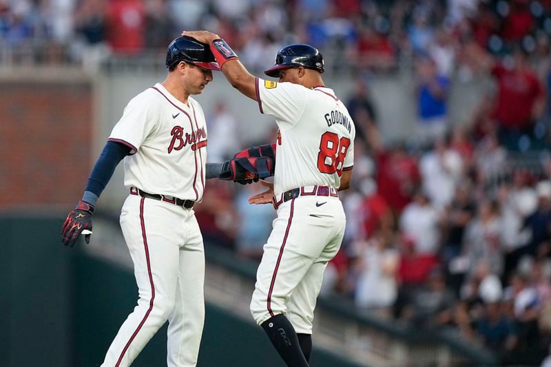 Atlanta Braves' Austin Riley (27) is congratulated by first base coach Tom Goodwin (88) after hitting a double in the fifth inning of a baseball game against the San Francisco Giants, Wednesday, July 3, 2024, in Atlanta. (AP Photo/Brynn Anderson)