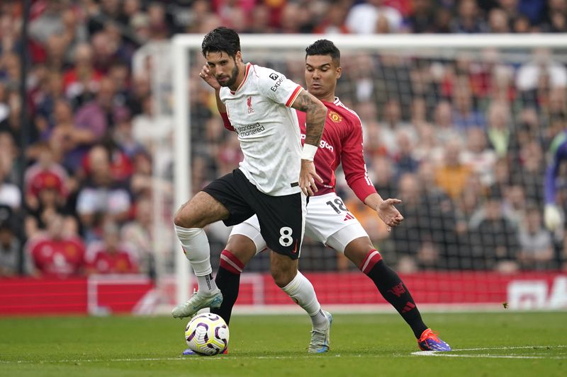 Liverpool's Dominik Szoboszlai, left, challenges for the ball with Manchester United's Casemiro during the English Premier League soccer match between Manchester United and Liverpool at Old Trafford, Sunday, Sept. 1, 2024, in Manchester, England. (AP Photo/Dave Thompson)