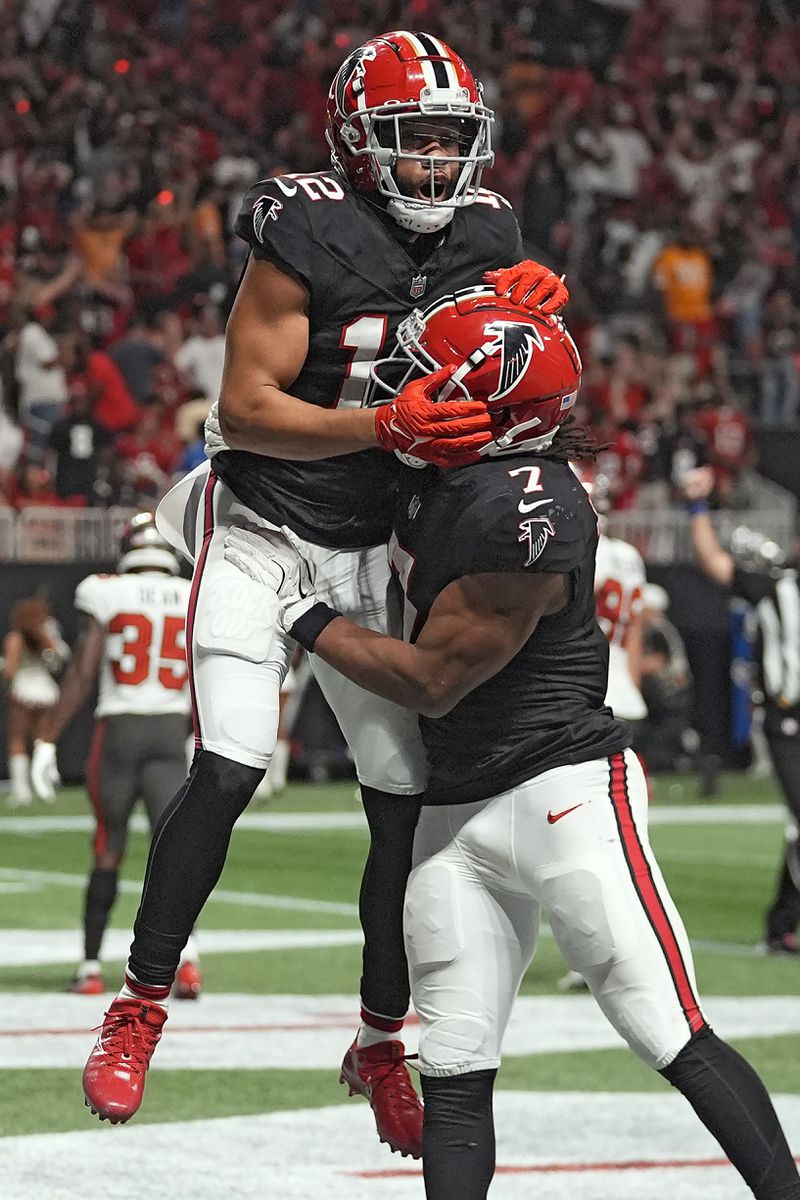 Atlanta Falcons wide receiver KhaDarel Hodge (12) celebrates with running back Bijan Robinson (7) after Hodge scored the game-wining touchdown against the Tampa Bay Buccaneers during overtime in an NFL football game Thursday, Oct. 3, 2024, in Atlanta. (AP Photo/John Bazemore)