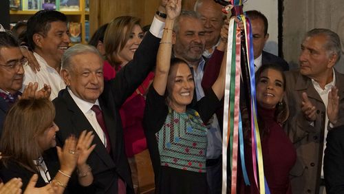 FILE - Mexican President Andres Manuel Lopez Obrador raises the hand of Claudia Sheinbaum, the ruling party's presidential candidate, during a ceremony to give her the party's command staff in Mexico City, Sept. 7, 2023. (AP Photo/Marco Ugarte, File)