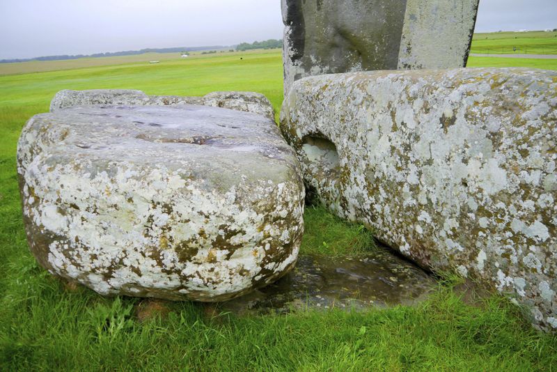 In this photo provided by researchers in August 2024, Stonehenge's Altar Stone lies underneath two Sarsen stones in Wiltshire, England. (Nick Pearce/Aberystwyth University via AP)