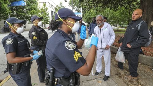 In an April 2020 file photo, Atlanta police officer Brittany Searight, Sgt. Sabrina Smith and Sgt. Dominique Simmons distribute masks at Hurt Park in downtown Atlanta. JOHN SPINK/SPINK@AJC.COM