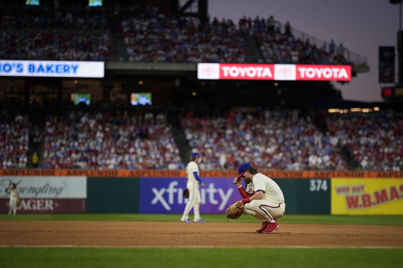 Philadelphia Phillies first base Bryce Harper rests during a pitching change during the eighth inning of Game 1 of a baseball NL Division Series against the New York Mets, Saturday, Oct. 5, 2024, in Philadelphia. (AP Photo/Matt Slocum)