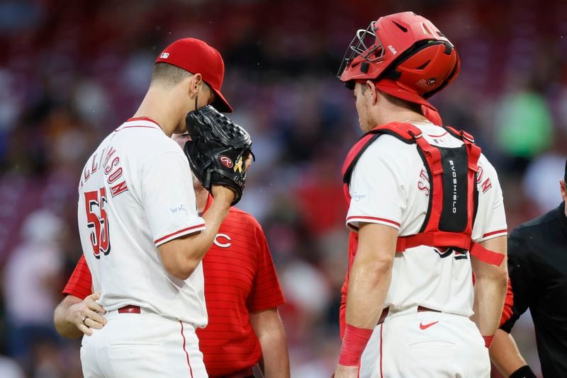 Cincinnati Reds starting pitcher Brandon Williamson, left, talks with catcher Tyler Stephenson and a trainer before being taken out of the game with an injury against the Atlanta Braves during the second inning of a baseball game Tuesday, Sept. 17, 2024, in Cincinnati. (AP Photo/Jay LaPrete)