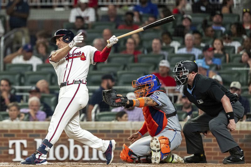 New York Mets catcher Francisco Alvarez, center, catches the ball as Atlanta Braves' Ramón Laureano, left, swings at a pitch in the third inning of a baseball game, Tuesday, Sept. 24, 2024, in Atlanta. (AP Photo/Jason Allen)