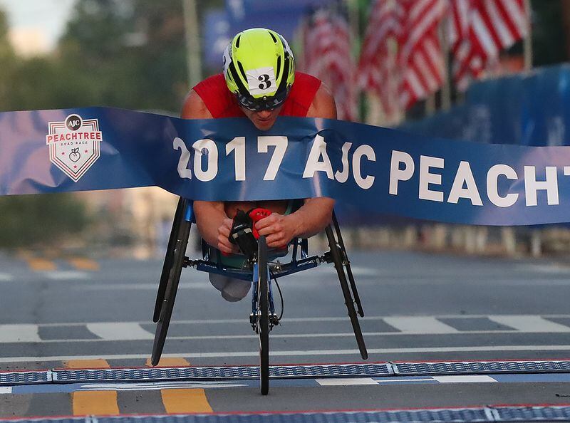 Daniel Romanchuk hits the finish line to win the men's wheelchair race in 2017.    Curtis Compton/ccompton@ajc.com