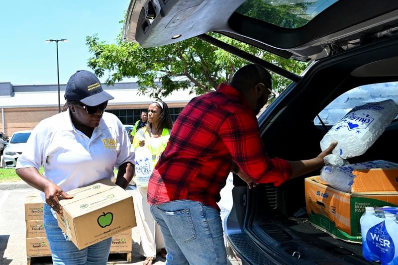 Volunteers help to hand out ice and supplies at Acres Homes cooling center in Houston, Wednesday, July 10, 2024. After Hurricane Beryl slammed into Texas, knocking out power to nearly 3 million homes and businesses. (AP Photo/Maria Lysaker)