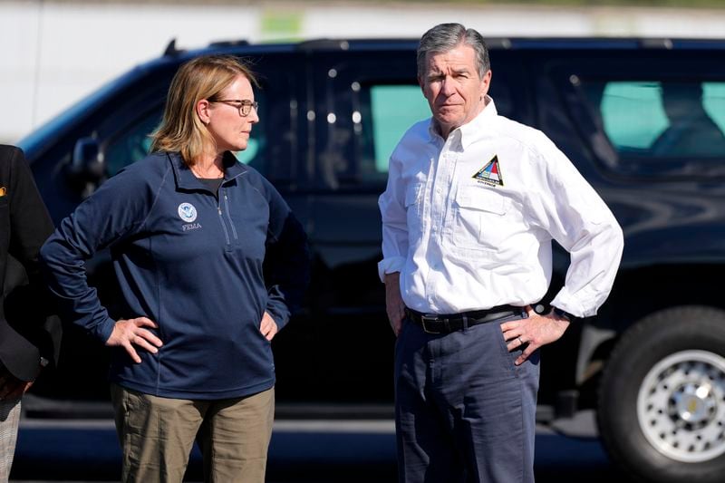 North Carolina Gov. Roy Cooper, right, and Deanne Criswell, Administrator of the U.S. Federal Emergency Management Agency, await the arrival of Democratic presidential nominee Vice President Kamala Harris for a briefing on the damage from Hurricane Helene, at Charlotte Douglas International Airport, Saturday, October 5, 2024, in Charlotte, N.C. (AP Photo/Chris Carlson)