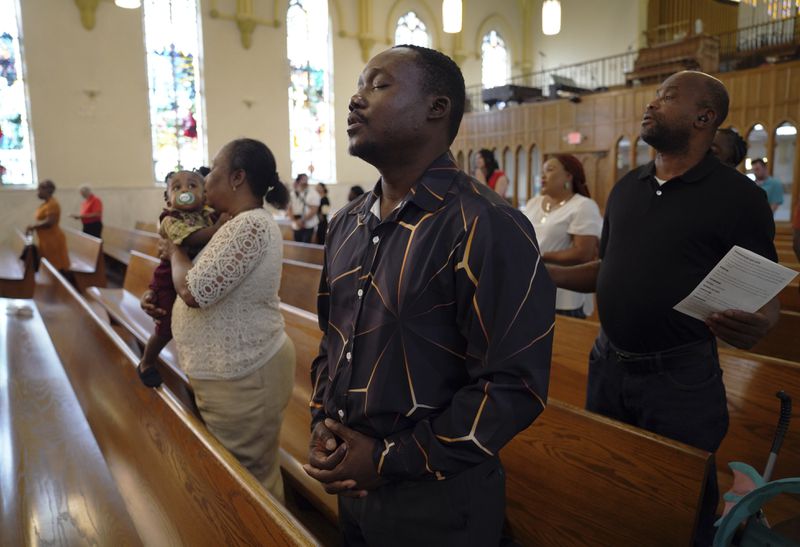 Congregants worship at St Raphael Catholic church in Springfield, Ohio, Sunday, Sept. 15, 2024. (AP Photo/Jessie Wardarski)