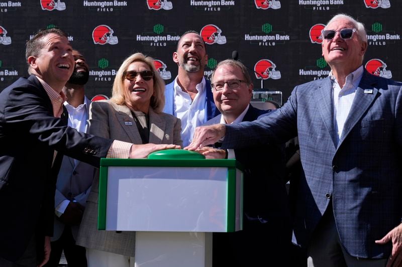 From left, Brant Standridge of Huntington Bank, Dee Haslam, Cleveland Browns owner, Steve Steinour of Huntington Bank and Jimmy Haslam, Cleveland Browns owner laugh after pressing a button to display "Huntington Bank Field" on the scoreboard at an NFL football news conference announcing Cleveland Browns Stadium will now be called Huntington Bank Field, Tuesday, Sept. 3, 2024, in Cleveland. At rear is David Jenkins, Browns' chief operating officer. (AP Photo/Sue Ogrocki)