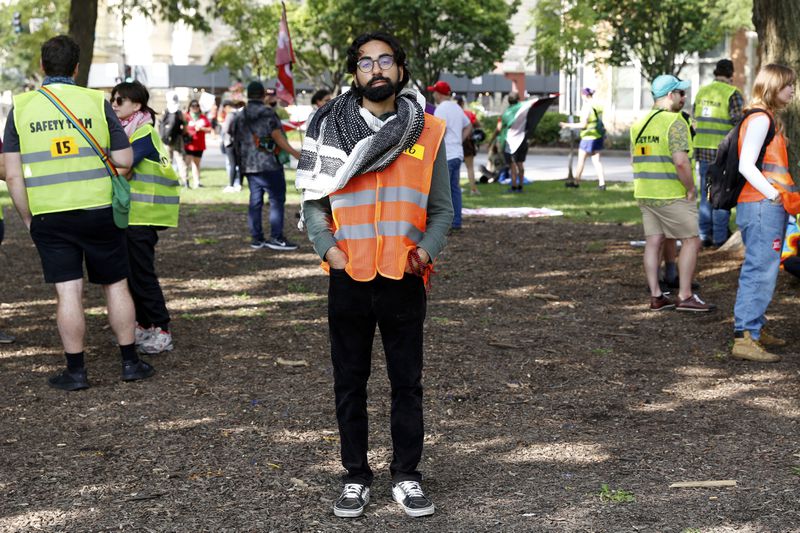 YM Masood, center, stands at Union Park in Chicago on Monday, Aug. 19, 2024. (AP Photo/Martha Irvine)