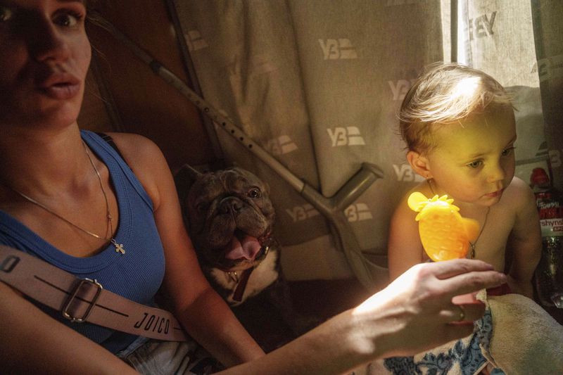 A girl sits in evacuation train in Pokrovsk, Donetsk region, Ukraine, Monday, August 19, 2024. Due to the advance of Russian troops, the war affects more and more new settlements to the west of the Donetsk region. Intensive shelling forced people to leave homes. (AP Photo/Evgeniy Maloletka)