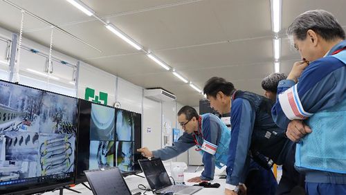 In this photo released by Tokyo Electric Power Company Holdings (TEPCO), TEPCO executives observe plant officials making final procedural checks from an operation room to monitor and remote control an extendable robot, at Fukjushima Daiichi nuclear power plant in Okuma, Fukushima prefecture, northern Japan Monday, Sept. 9, 2024. (Tokyo Electric Power Company Holdings via AP)