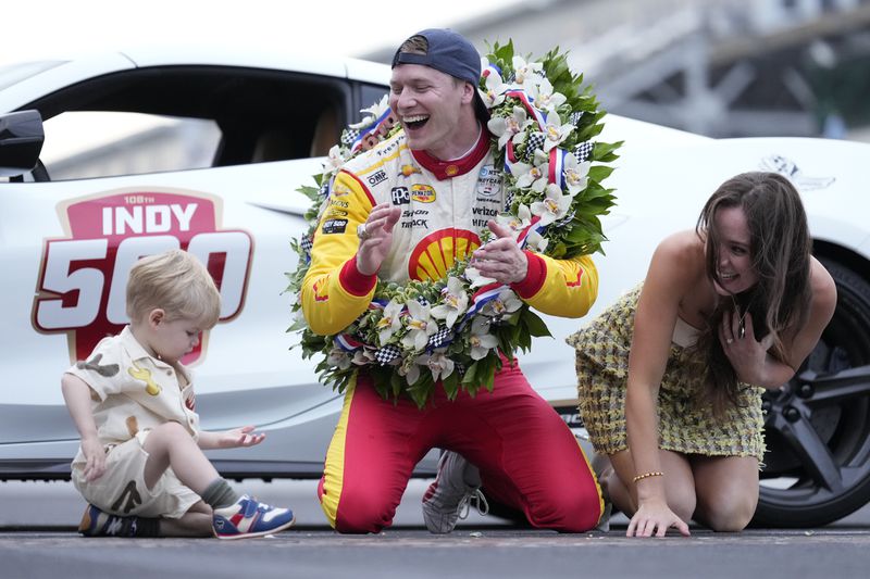 Josef Newgarden, center, celebrates with his son Kota and wife Ashley Welch after winning the Indianapolis 500 auto race at Indianapolis Motor Speedway in Indianapolis, Sunday, May 26, 2024. (AP Photo/AJ Mast)