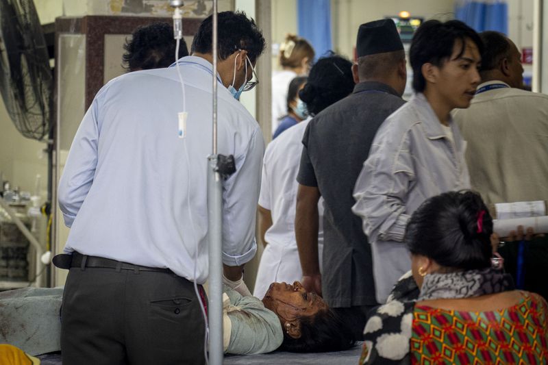 An injured woman is brought for treatment at a hospital, after a bus carrying Indian tourists fell into a river near Abukhaireni town about 75 miles west of the capital Kathmandu, Nepal, Friday, Aug. 23, 2024. (AP Photo/Niranjan Shrestha)