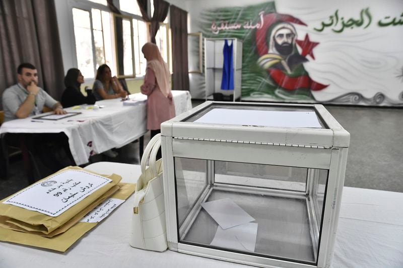 Election officials wait for voters inside a polling station during the presidential election, Saturday, Sept. 7, 2024, in Algiers, Algeria. (AP Photo/Fateh Guidoum)