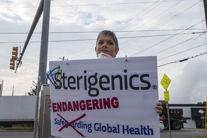 08/02/2019 — Smyrna, Georgia — Stop Sterigenics Georgia member Lynn Bixler holds a sign as she and other supporters protest against Sterigenics near the plant in Smyrna, Friday, August 2, 2019. Stop Sterigenics Georgia is an organization that is concerned about the Ethylene Oxide pollution that the Sterigenics plant is producing in the area. (Alyssa Pointer/alyssa.pointer@ajc.com)