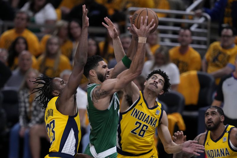 Boston Celtics forward Jayson Tatum, center, drives to the basket between Indiana Pacers forward Aaron Nesmith (23) and guard Ben Sheppard (26) during the first half of Game 3 of the NBA Eastern Conference basketball finals, Saturday, May 25, 2024, in Indianapolis. (AP Photo/Darron Cummings)