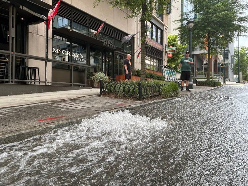 Water flows on West Peachtree Street in front of McCray's Tavern Midtown on Sunday. 