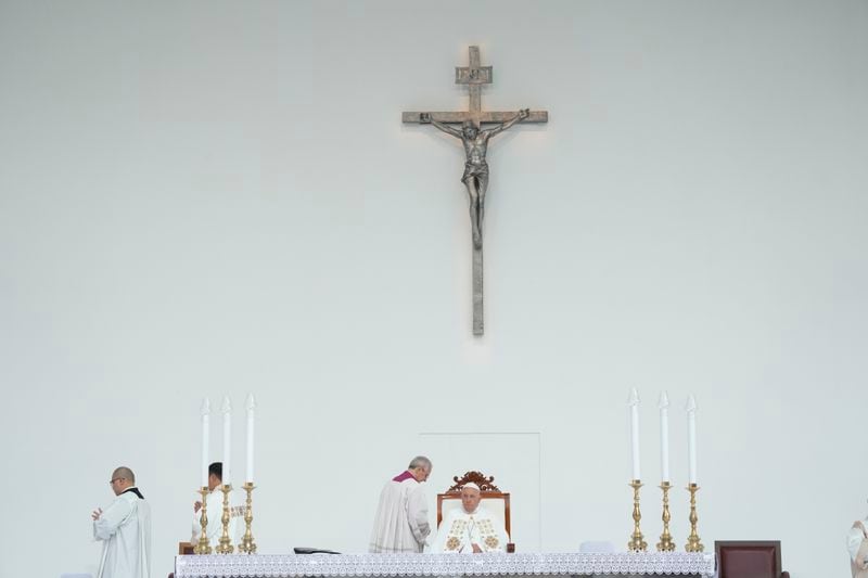 Pope Francis, is helped by his aide Bishop Diego Ravelli, center left, as he arrives to preside over a memorial mass in the name of Saint Mother Teresa of Calcutta for some 60 thousand faithful inside Jakarta's Gelora Bung Karno stadium, Thursday, Sept. 5, 2024. Francis traveled to Indonesia, at the start of an 11-day, four-nation trip to Asia and Oceania, to encourage Indonesia to combat religiously inspired violence and pledge the Catholic Church's commitment to greater fraternity. (AP Photo/Gregorio Borgia)