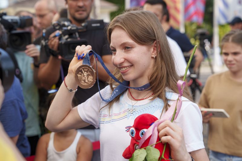 Romanian gymnast Ana Barbosu poses with the bronze medal for her women's artistic gymnastics individual floor performance at the Paris 2024 Olympics, after receiving it during a ceremony at the Romanian Olympic and Sports Committee, in Bucharest, Romania, Friday, Aug. 16, 2024. American gymnast Jordan Chiles called an arbitration panel's decision that dropped her out of the bronze medal position in the floor exercise at the Paris Olympics "unjust" and a "significant blow" in a message posted on social media Thursday. (AP Photo/Vadim Ghirda)