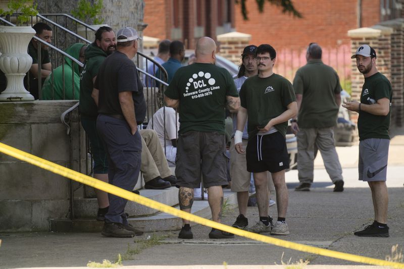 Delaware County Linen employees gather across the street from their workplace where a fatal shooting accoured Chester, Pa., Wednesday, May 22, 2024. Authorities say a former employee armed with a handgun opened fire at a linen company in a Philadelphia suburb, killing multiple people and wounding three others. (AP Photo/Matt Rourke)