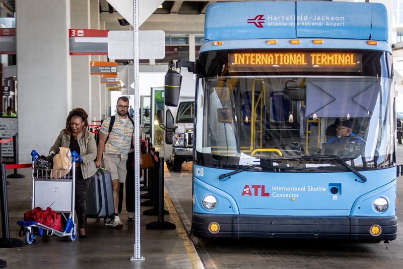 Passengers board the terminal-to-terminal shuttle at the international terminal on Tuesday, Sept. 29, 2023.  (Steve Schaefer/steve.schaefer@ajc.com)