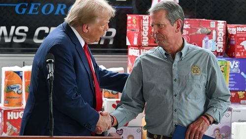 Former President Donald Trump greets Gov. Brian Kemp during a press event Friday in Evans as they toured east Georgia to survey damage from Hurricane Helene. (Hyosub Shin / AJC)