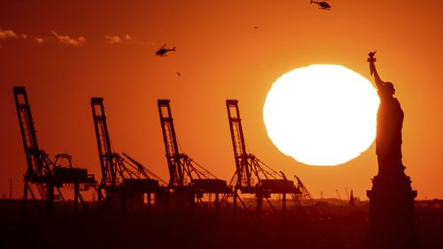 FILE - Cranes at the Port of New York and New Jersey appear behind the Statue of Liberty, Nov. 20, 2022, in a photo taken from New York. (AP Photo/Julia Nikhinson, File)