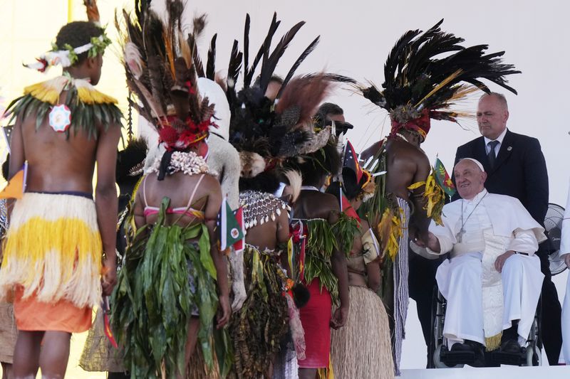 Pope Francis meets with people in traditional dress after giving an address during meeting with young people in the Sir John Guise Stadium in Port Moresby, Papua New Guinea, Monday, Sept. 9, 2024. (AP Photo/Mark Baker)