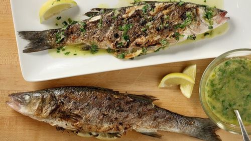For the herb-grilled Mediterranean sea bass recipe, the fish are drizzled after grilling with a lemon, ginger and chive finishing sauce. (Michael Tercha/Chicago Tribune/TNS)