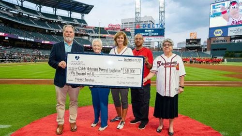 Left to Right: Atlanta Braves Foundation Board Member and President & CEO Mike Plant, left, presents members of the Cobb Veterans Memorial Foundation with a $50,000 donation during a Sept. 14 ballgame at Truist Park. From left to right: Plant, Cobb Veterans Memorial Foundation President Donna Rowe, CVMF Vice President Shelley O’Malley, CVMF board member U.S. Air Force Maj. Gen. Curtis Williams, and Cobb County District 3 Commissioner JoAnn Birrell. (Photo provided by Kevin
Liles/Atlanta Braves)