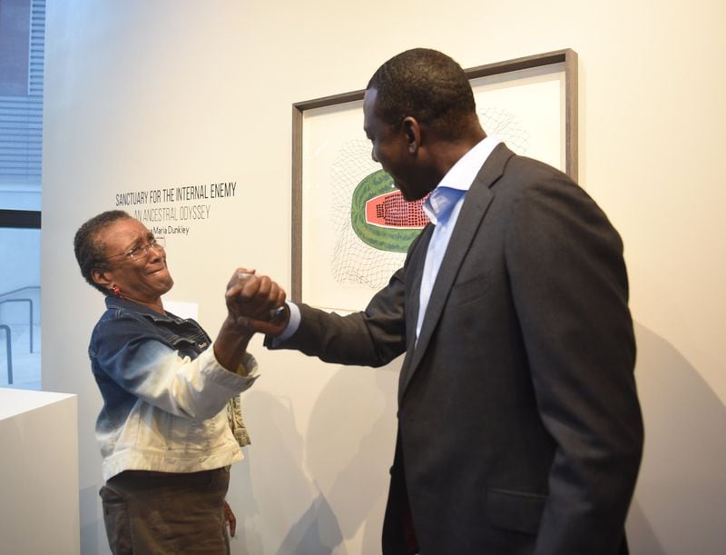 Yusef Salaam and artist Tina Dunkley share a moment at the Auburn Avenue Research Library. The two realized they attended the same high school in Harlem, N.Y., though not at the same time. 