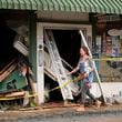 A person walks past a building heavily damaged during Hurricane Helene Tuesday, Oct. 1, 2024, in Hot Springs, N.C. (AP Photo/Jeff Roberson)