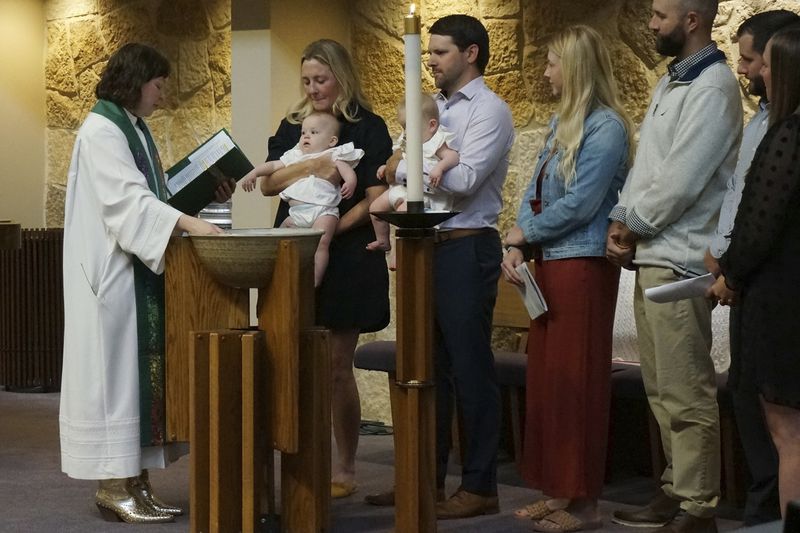 The Rev. Elise Pokel performs baptisms at Transfiguration Lutheran Church in Bloomington, Minn, on Sept. 8, 2024. (AP Photo/Giovanna Dell'Orto)