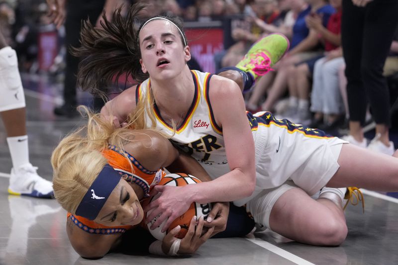 Indiana Fever guard Caitlin Clark, top, and Connecticut Sun guard DiJonai Carrington (21) go to the floor for a loose ball in the second half of a WNBA basketball game in Indianapolis, Wednesday, Aug. 28, 2024. (AP Photo/Michael Conroy)