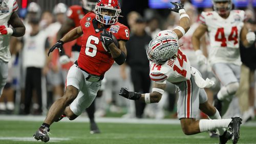 Georgia running back Kenny McIntosh gets by Ohio State safety Ronnie Hickman for a 52-yard run during the second quarter in the Peach Bowl. Georgia won 42-41. (Jason Getz / Jason.Getz@ajc.com)