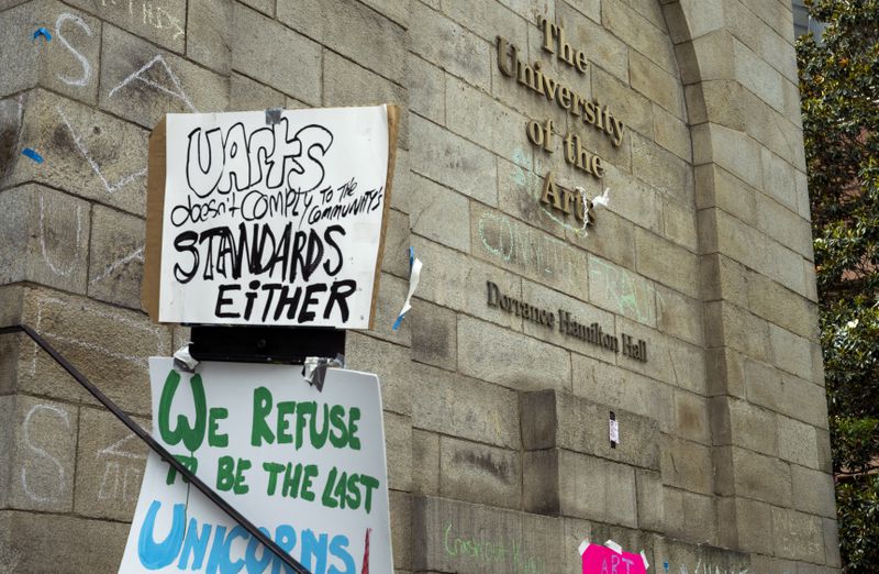 Signs and writing denouncing the closure of the University of the Arts are pictured at Dorrance Hamilton Hall on Friday, June 14, 2024, in Philadelphia. (AP Photo/Joe Lamberti)