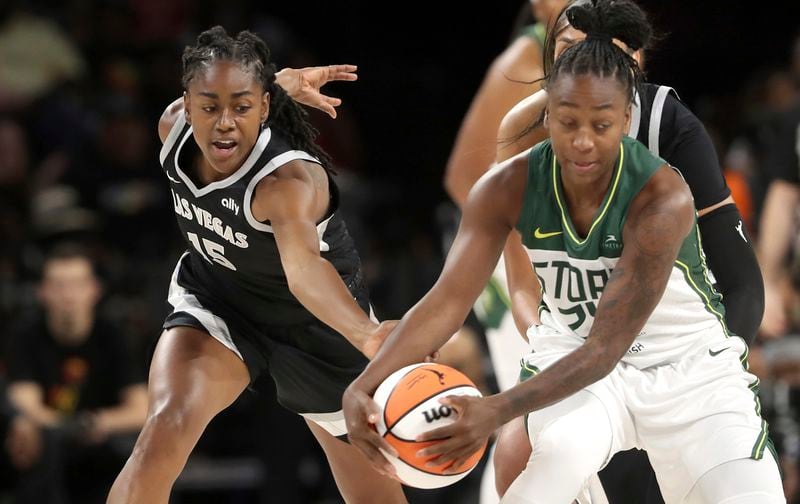 Las Vegas Aces guard Tiffany Hayes (15) and Seattle Storm guard Jewell Loyd (24) fight for the ball during the first half of an WNBA basketball game Wednesday, June 19, 2024, in Las Vegas. (Steve Marcus/Las Vegas Sun via AP)