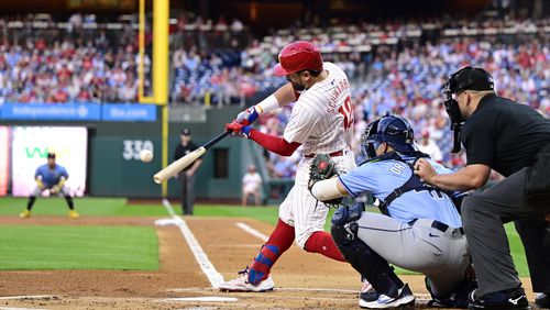 Philadelphia Phillies' Kyle Schwarber, center, hits a solo home run off Tampa Bay Rays' Taj Bradley during the first inning of a baseball game, Tuesday, Sept. 10, 2024, in Philadelphia. (AP Photo/Derik Hamilton)