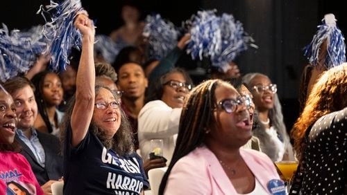 People cheer while watching the final night of the Democratic National Convention during a party Thursday at the Gathering Spot in Atlanta. (Ben Gray for The Atlanta Journal-Constitution)