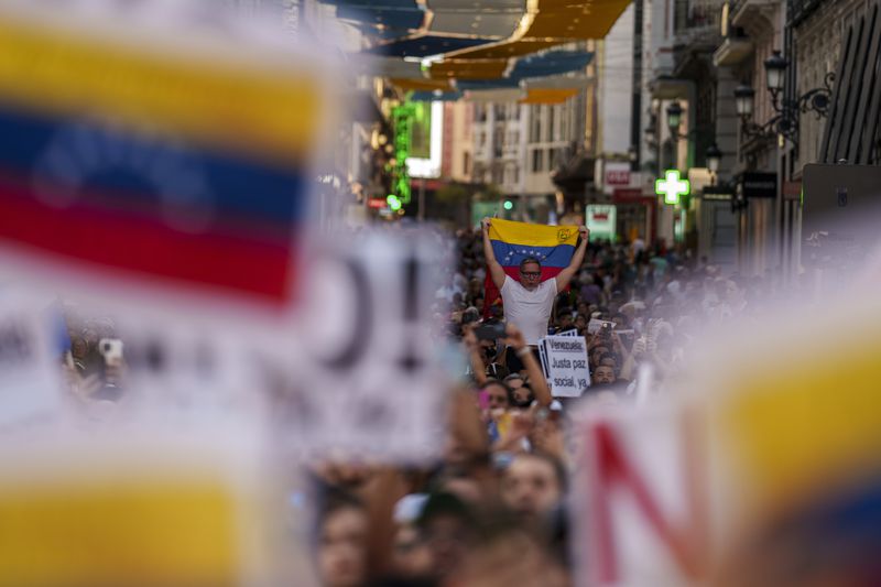 People take part during a protest against the official results that declared President Nicolas Maduro the winner of the July presidential election in Madrid, Spain, Saturday, Aug. 17, 2024. (AP Photo/Manu Fernandez)