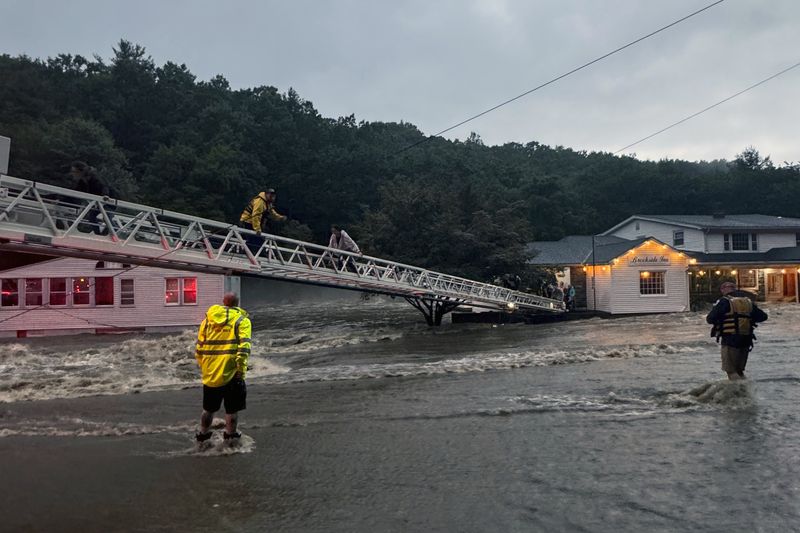 This photo provided by Beacon Hose Co. No. 1, a fire station in Beacon Falls, Connecticut, shows members of Beacon Hose Co. rescuing people from the Brookside Inn in Oxford, Conn., Sunday, Aug. 18, 2024. (Beacon Hose Co via AP)