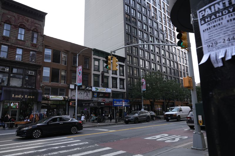 Cars drive past buildings in the Harlem neighborhood of New York are pictured Thursday, Aug. 15, 2024. (AP Photo/Pamela Smith)