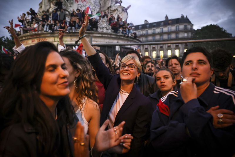 FILE - Actress Judith Godreche, center, waves during a gathering at Republique plaza in a protest against the far-right, Wednesday, July 3, 2024 in Paris. French film director Benoit Jacquot accused by multiple actors of sexual assault and violent, controlling behavior, including when his alleged victims were teenagers, has been handed preliminary charges of rape, sexual assault and violence by a French judge investigating the case, the Paris prosecutor's office said Thursday, July 4, 2024. Godrèche, who alleges that Jacquot raped and physical abused her in a six-year relationship that started when she was 14, has taken a lead role in kickstarting the #MeToo wave, which struggled for traction before she spoke out and emboldened other actors to do so, too. (AP Photo/Thomas Padilla, File)
